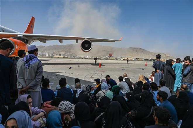 Đám đông người sơ tán chờ đợi được rời khỏi Afghanistan tại sân bay quốc tế ở Kabul ngày 16/8 khi Taliban tuyên bố kiểm soát quốc gia Tây Nam Á. (Ảnh: AFP/TTXVN) 600 nhân viên Afghanistan hỗ trợ đảm bảo an ninh ở sân bay Kabul ảnh 1