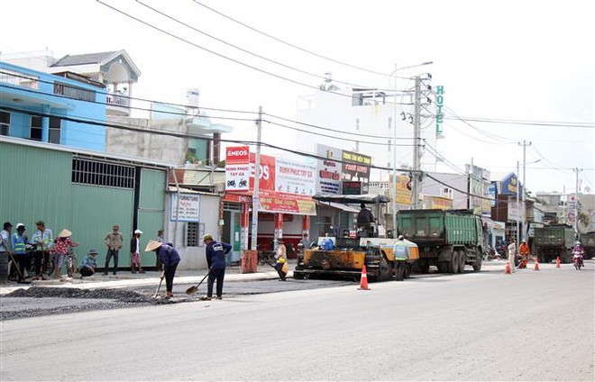 Các đơn vị thi công thảm nhựa tại dự án nâng cấp, mở rộng đường Tô Ký, Hóc Môn, TP.HCM. (Ảnh: Tiến Lực/TTXVN) Thúc đẩy giải ngân 100% vốn đầu tư công ở Thành phố Hồ Chí Minh ảnh 1