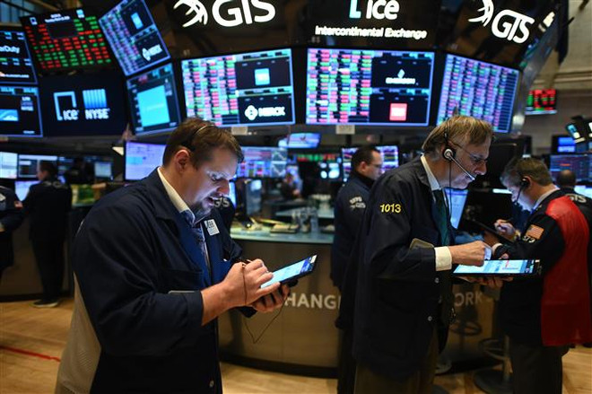 Giao dịch viên làm việc tại sàn giao dịch chứng khoán New York, Mỹ. (Ảnh: AFP/TTXVN) Chứng khoán Mỹ nối dài đà tăng, đồng bitcoin được Tesla 'tiếp sức' ảnh 1