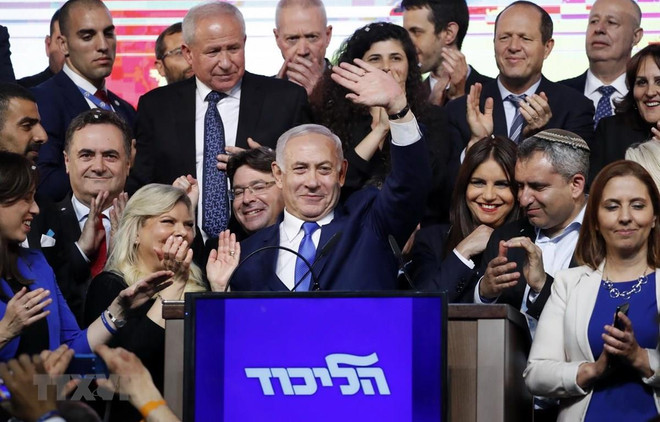 Thủ tướng Israel Benjamin Netanyahu (giữa) vẫy chào những người ủng hộ sau khi kết quả bầu cử được công bố, tại trụ sở đảng Likud ở Tel Aviv, ngày 10/4. (Ảnh: AFP/TTXVN) Thủ tướng Israel Netanyahu được chỉ định thành lập chính phủ mới ảnh 1