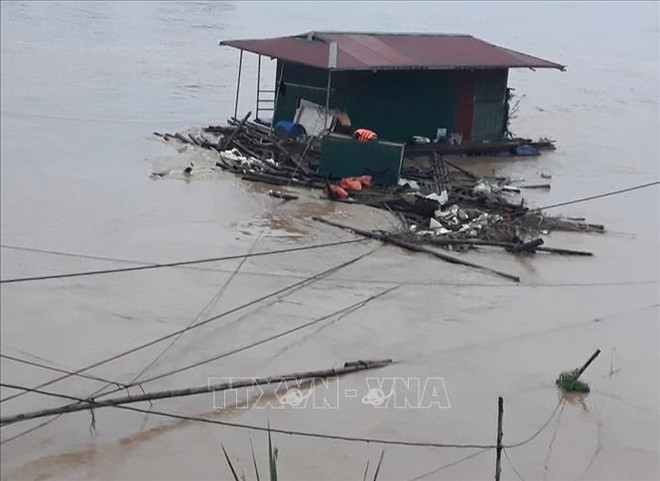 Nhà bè bị nhiều rác, cành cây, gỗ trôi từ phía thượng nguồn về mắc vào xung quanh, dưới gầm, tạo thành mảng lớn. (Ảnh: TTXVN) Cứu hộ 3 người mắc kẹt và 2 bè cá bị lũ cuốn trôi trên sông Lô ảnh 1