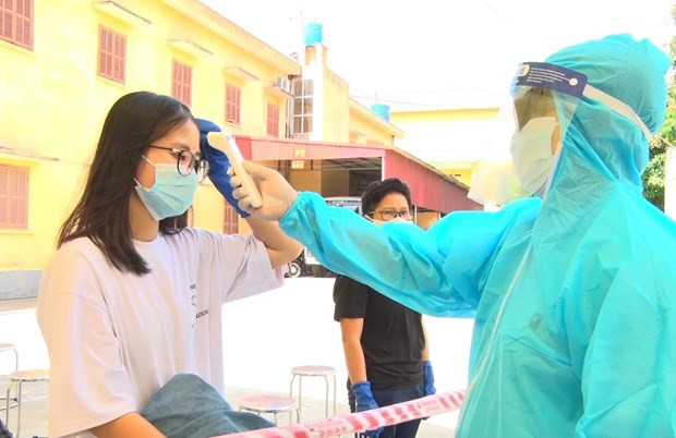 Bác sỹ kiểm tra thân nhiệt cho công dân. (Ảnh: Đinh Tuấn/TTXVN) Việt Nam ghi nhận thêm 3 ca mắc COVID-19, được cách ly ngay ảnh 1