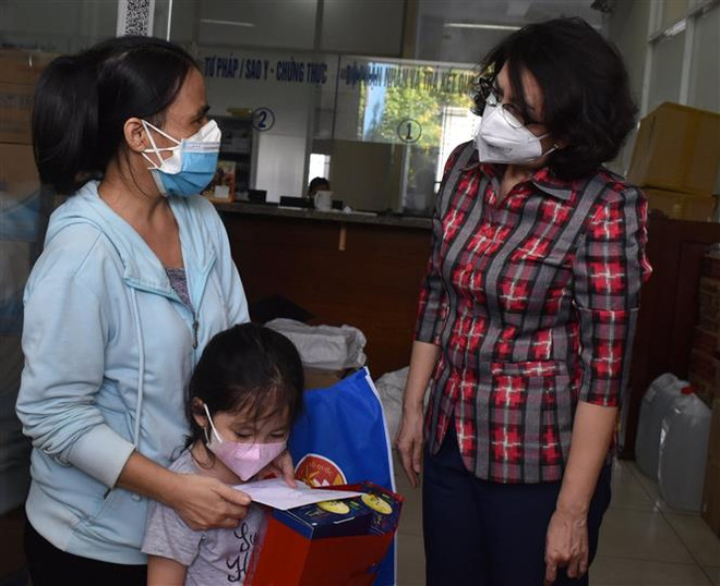 Chủ tịch Ủy ban Mặt trận Tổ quốc Thành phố Hồ Chí Minh Tô Thị Bích Châu thăm hỏi và tặng quà cho các em mồ côi vì COVID-19 tại quận 4. (Ảnh: Thu Hương/TTXVN) TP.HCM đề xuất chính sách hỗ trợ người cao tuổi neo đơn và trẻ mồ côi ảnh 1
