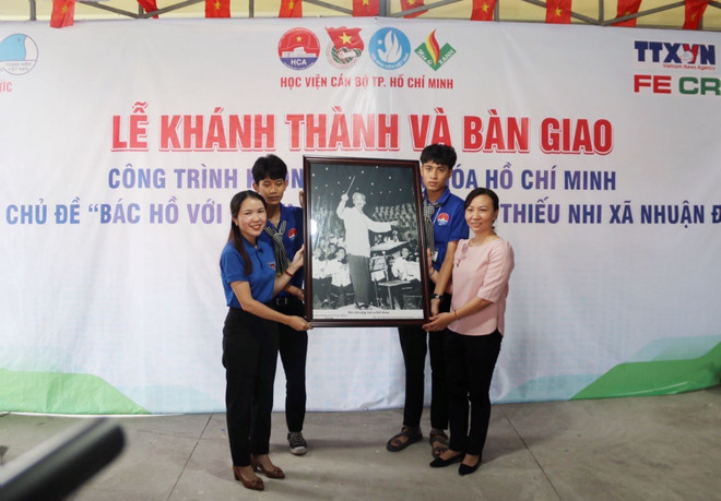 Đại diện Cơ quan thường trú TTXVN tại Thành phố Hồ Chí Minh tặng bức ảnh Chủ tịch Hồ Chí Minh cho Ủy ban Nhân dân xã Nhuận Đức. (Ảnh: Thu Hương/TTXVN) TP.HCM: Đưa không gian văn hóa Hồ Chí Minh đến với thiếu nhi ảnh 1