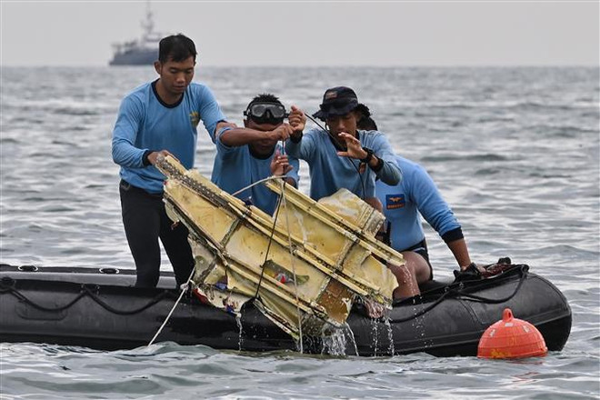 Lực lượng cứu hộ Indonesia tìm thấy mảnh vỡ của chiếc máy bay gặp nạn tại khu vực gần đảo Lancang, ngày 10/1/2021. (Ảnh: AFP/TTXVN) Vụ máy bay rơi ở Indonesia: Bắt đầu điều tra nguyên nhân tai nạn ảnh 1