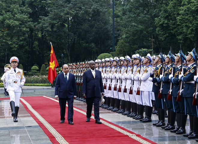 Chủ tịch nước Nguyễn Xuân Phúc và Tổng thống Uganda Yoweri Kaguta Museveni duyệt Đội danh dự Quân đội nhân dân Việt Nam. (Ảnh: Thống Nhất/TTXVN) Thúc đẩy quan hệ song phương giữa hai nước Việt Nam và Uganda ảnh 2