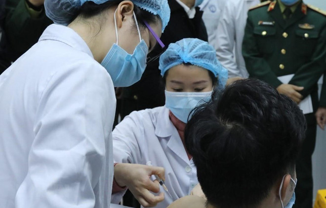Sáng 17/12/2020, tại Học viện Quân y (Hà Nội), Bộ Y tế phối hợp với Bộ Quốc phòng, Bộ Khoa học và Công nghệ tổ chức tiêm thử nghiệm mũi vắcxin Nanocovax ngừa COVID-19 đầu tiên trên 3 người tình nguyện. (Ảnh: TTXVN) 'Việc thử nghiệm vắcxin ngừa COVID-19 tuân thủ chặt hướng dẫn của WHO' ảnh 1