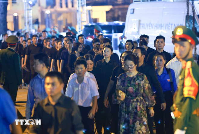 Càng về đêm, dòng người hướng về Nhà Tang lễ Quốc gia càng đông. (Ảnh: TTXVN) ttxvn_le vieng nha tang le quoc gia dem 2507 (19).jpg