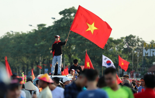Cổ động viên cổ vũ đội tuyển Việt Nam bên ngoài sân vận động Mỹ Đình. (Ảnh: Thành Đạt/TTXVN) Người hâm mộ "truyền lửa" cho thầy trò huấn luyện viên Park Hang-seo ảnh 1