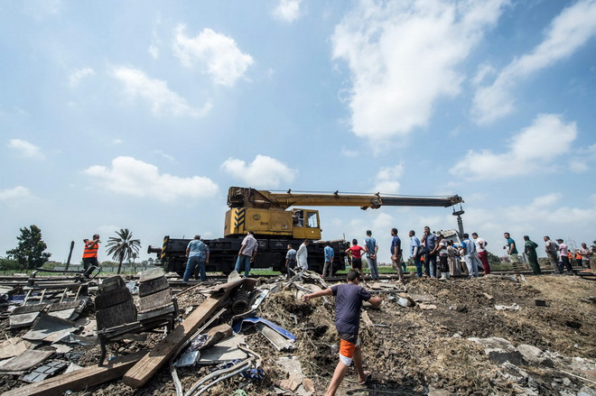 Khắc phục hậu quả tại hiện trường vụ tai nạn ở Alexandria. (Nguồn: AFP/TTXVN) Tai nạn đường sắt làm 49 người chết: Ai Cập kết án tù lái tàu ảnh 1