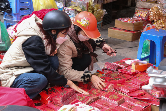 Khách hàng tự tay lựa chọn những mẫu phong bao lì xì theo sở thích cá nhân. (Ảnh: Việt Anh/Vietnam+) Thị trường phong bao lì xì Tết nhộn nhịp với nhiều mẫu mã mới lạ ảnh 1
