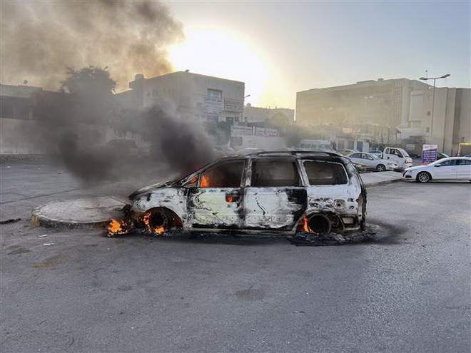Ôtô bị đốt cháy trong các vụ đụng độ tại Tripoli, Libya, ngày 27/8. (Ảnh: THX/TTXVN) Tình hình Libya: Các cuộc giao tranh tạm lắng ở thủ đô Tripoli ảnh 1