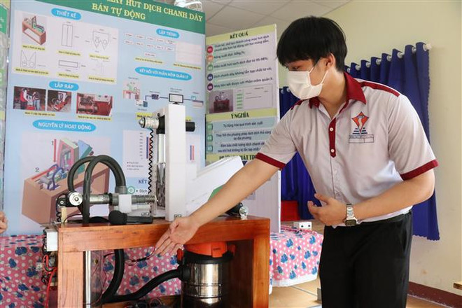 Em Đào Huỳnh Duy An giới thiệu máy hút dịch chanh dây bán tự động. (Ảnh: Tuấn Anh/TTXVN) Hai học sinh chế tạo máy hút dịch chanh dây để hỗ trợ nông dân ảnh 2