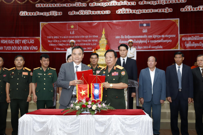Đại diện Ban Công tác đặc biệt của Lào trao Biên bản bàn giao các hài cốt cho Đại diện Đội quy tập Quân khu 2. (Ảnh: Phạm Kiên /TTXVN) Hồi hương 10 hài cốt liệt sỹ Việt Nam hy sinh tại 6 tỉnh Bắc Lào ảnh 2