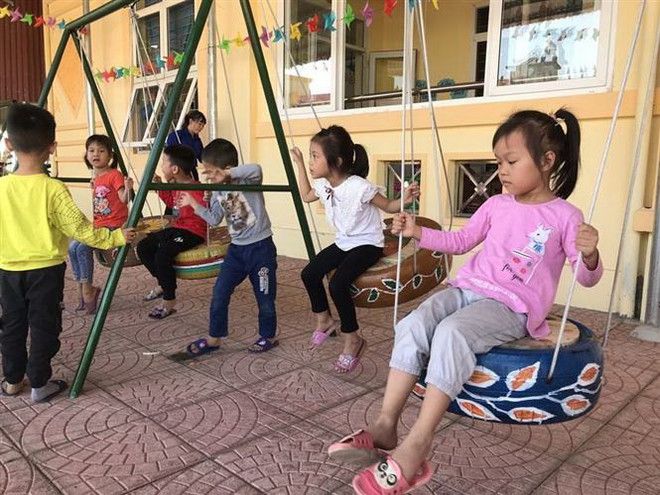 Các cháu chơi trò chơi xích đu làm từ lốp xe hỏng. (Ảnh: Tiến Vĩnh/TTXVN) Hải Dương: Biến những chiếc lốp xe hỏng thành đồ chơi hữu ích cho trẻ ảnh 1