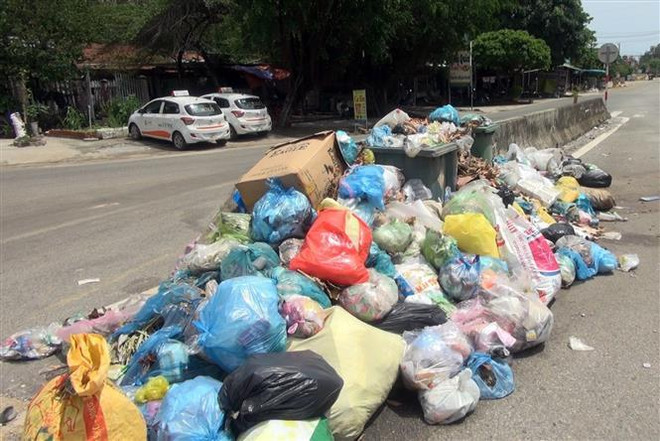 Rác thải ùn ứ trên đường ở khối phố 4, thị trấn Núi Thành, huyện Núi Thành, Quảng Nam. (Ảnh: Đỗ Trưởng/TTXVN) Quảng Nam: Ứ đọng khoảng 7.000 khối rác, nguy cơ ô nhiễm trầm trọng ảnh 1