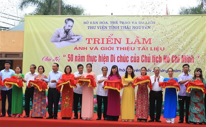 Các đại biểu cắt băng khai mạc triển lãm. (Ảnh: Quân Trang/TTXVN) Giới thiệu nhiều bức ảnh tư liệu quý giá về Chủ tịch Hồ Chí Minh ảnh 1