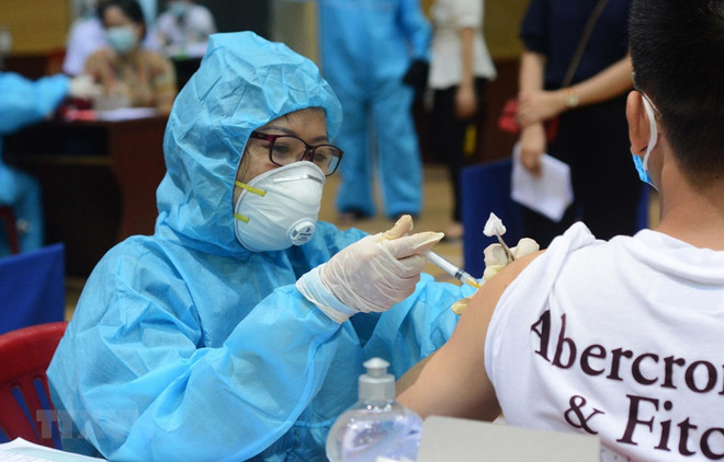 Nhân viên y tế tiêm vaccine phòng COVID-19 cho người dân tại Đà Nẵng. (Ảnh: Văn Dũng/TTXVN) Đà Nẵng đã qua đỉnh dịch COVID-19, số ca mắc giảm 6,6 lần ảnh 1