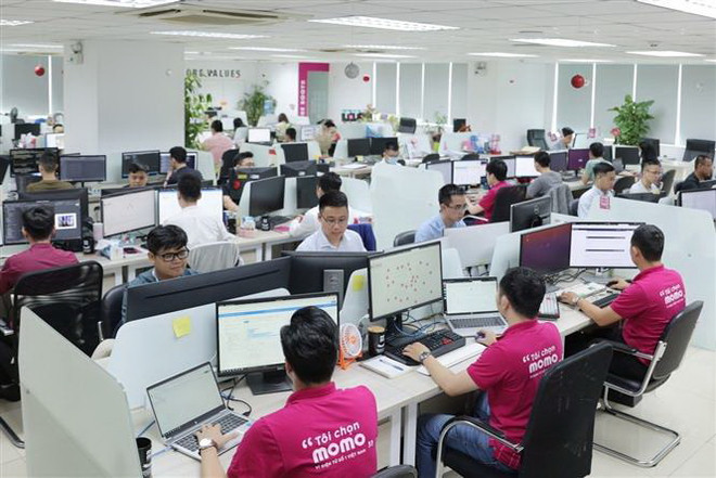 Các nhân viên của Ví điện tử MoMo làm việc tại văn phòng. (Ảnh: TTXVN phát) Thúc đẩy đổi mới sáng tạo, tạo động lực tăng trưởng mới ảnh 1