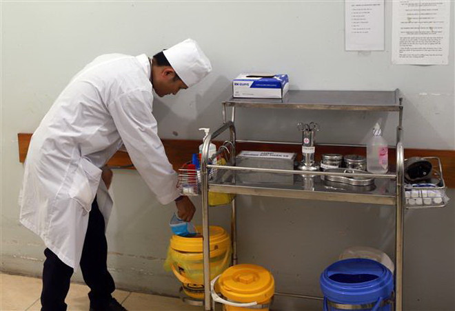 Bác sỹ Trung tâm y tế huyện Bình Xuyên bỏ khẩu trang đã sử dụng vào thùng lưu chứa chất thải. (Ảnh: Hoàng Hùng/TTXVN) Vĩnh Phúc thực hiện nghiêm việc xử lý rác thải trong vùng dịch ảnh 2
