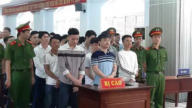 Bị cáo Nguyễn Văn Hưng (hàng đầu tiên, từ phải qua trái) cùng các bị cáo trong phiên tòa sáng 28/2. (Ảnh: Ngọc Sơn/TTXVN) Phạt tù nhóm đối tượng giết người do mâu thuẫn khi đánh bạc ảnh 1