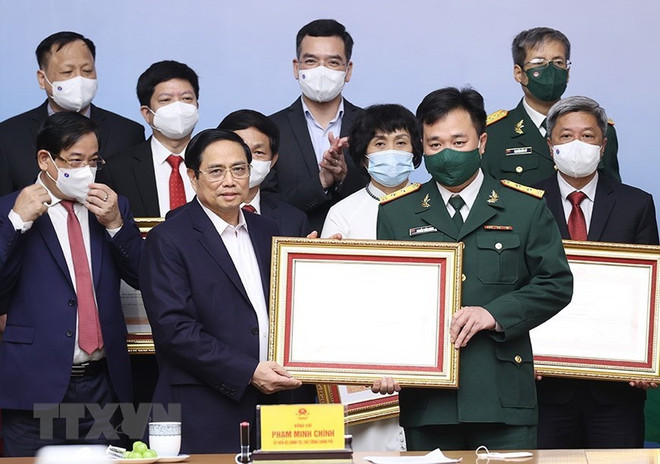 Thủ tướng Phạm Minh Chính trao Bằng khen cho các cá nhân tiêu biểu, xuất sắc trong công tác phòng, chống dịch COVID-19. (Ảnh: Dương Giang/TTXVN) Thủ tướng: Vai trò của lực lượng tuyến đầu còn rất nặng nề ảnh 2
