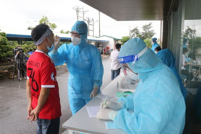 Lấy mẫu xét nghiệm cho người dân ở Bỉm Sơn, Thanh Hóa. (Nguồn: TTXVN) Thanh Hóa: Thêm nhiều ca dương tính, học sinh Bỉm Sơn dừng đến trường ảnh 1