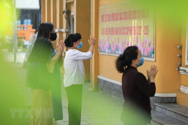 Người dân và phật tử thành tâm vái vọng bên ngoài một ngôi chùa. (Ảnh: Minh Đức/TTXVN) Đón mùa Phật đản an lành trong làn sóng dịch bệnh COVID-19 ảnh 2