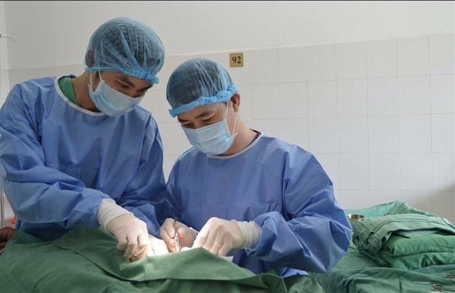 Bác sỹ phẫu thuật cho bệnh nhân. (Ảnh: TTXVN) Bất cẩn khi dùng máy cắt rau tự chế, một người bị lóc toàn bộ da đầu ảnh 1