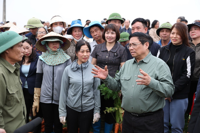 Thủ tướng Phạm Minh Chính nói chuyện và động viên nông dân trồng cà rốt tại xã Đức Chính, huyện Cẩm Giàng, Hải Dương. (Ảnh: Dương Giang/TTXVN) ttxvn_thu tuong xuong dong 3.jpg