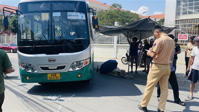 Hiện trường vụ tai nạn khiến em học sinh tử vong dưới gầm xe bus. (Ảnh: Lê Xuân/TTXVN) Đồng Nai: Tài xế xe đưa đón lùi xe bất cẩn, một học sinh lớp 3 tử vong ảnh 1