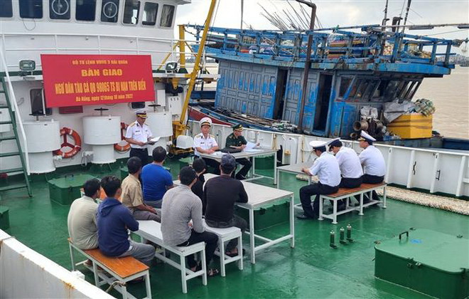 Vùng 3 Hải quân tiến hành bàn giao tàu cá và 7 ngư dân cho lực lượng chức năng thành phố Đà Nẵng. (Ảnh: Quốc Dũng/TTXVN) Tàu hải quân lai dắt tàu cá cùng 7 ngư dân gặp nạn trên biển về bờ ảnh 1