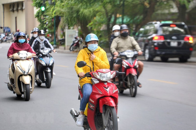 Người dân cần chuẩn bị quần áo ấm khi phải ra đường sáng sớm hoặc tối muộn. (Nguồn: TTXVN) Nhiệt độ giữa ngày và đêm ở khu vực Bắc Bộ chênh lệch 10 độ C ảnh 1