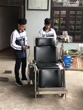 Hùng và Tân đang nghiên cứu thêm tính năng cho sản phẩm. (Ảnh: Hải Yến/TTXVN) Học sinh Ninh Bình sáng chế giường hỗ trợ người mất khả năng vận động ảnh 2