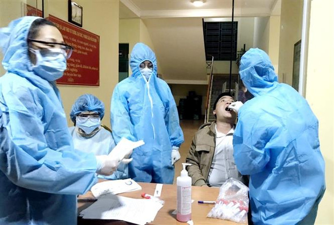 Nhân viên y tế Vân Đồn lấy mẫu xét nghiệm của người dân. (Ảnh: TTXVN phát) Hỗ trợ hai tỉnh Quảng Ninh, Hải Dương phòng, chống dịch COVID-19 ảnh 1