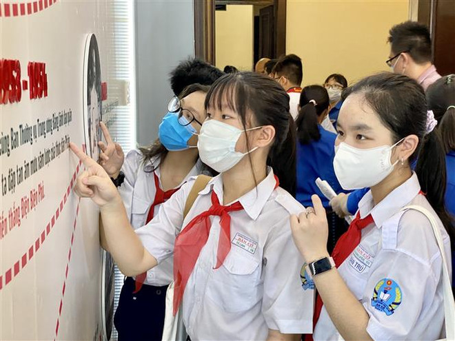 Các em đội viên tìm hiểu thông tin về cuộc đời và sự nghiệp của Chủ tịch Hồ Chí Minh. (Ảnh: Hồng Giang/TTXVN) Khánh thành công trình 'Không gian Bác Hồ với thiếu nhi' tại TP.HCM ảnh 1