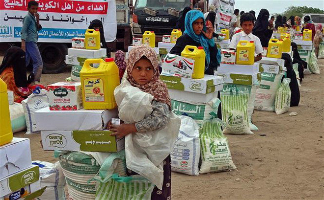 Người dân nhận hàng cứu trợ ở Hays, tỉnh Hodeida, miền Tây Yemen. (Ảnh: AFP/TTXVN) Trung Quốc kêu gọi đối thoại, tiến tới ngừng bắn toàn diện ở Yemen ảnh 1