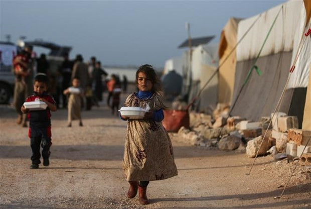 Trẻ tị nạn Syria nhận lương thực viện trợ từ một tổ chức từ thiện tại khu lều trại ở ngoại ô thị trấn Dana, phía Đông tỉnh biên giới Idlib. (Ảnh: AFP/TTXVN) Xung đột ở Syria: Jordan thúc đẩy kế hoạch hòa bình của các nước Arab ảnh 1