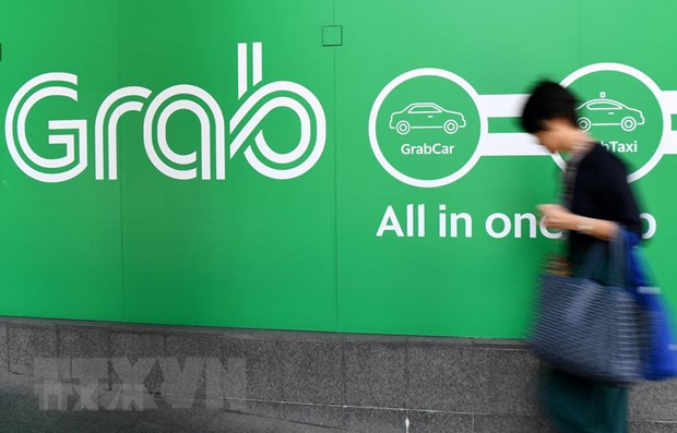 Biểu tượng hãng gọi xe công nghệ Grab tại văn phòng ở Singapore. (Ảnh: AFP/TTXVN) IPO của Grab và GoTo sẽ mở đường cho nhiều “kỳ lân” ra đời ảnh 1