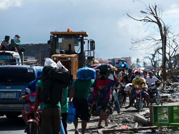 Những người sống sót sau bão Haiyan rời khỏi thành phố Tacloban ngày 14/11. (Nguồn: THX/TTXVN) Di chuyển 48 người Việt tại Philippines đến nơi an toàn ảnh 1