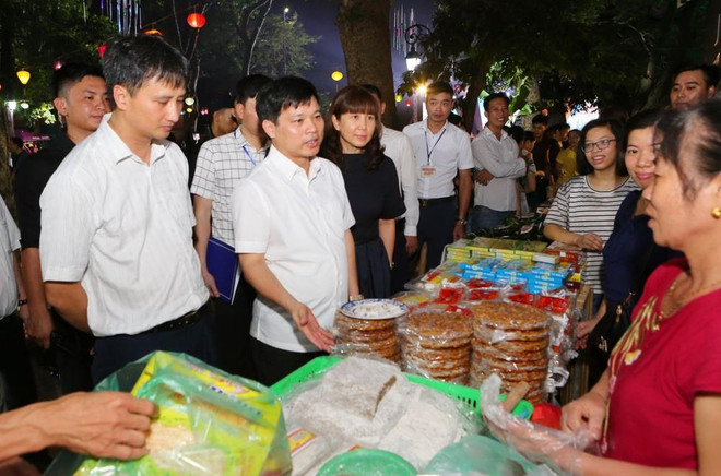 Ông Ngô Văn Quý, Phó Chủ tịch Ủy ban Nhân dân thành phố Hà Nội cùng các đại biểu tham quân các gian hàng ẩm thực. (Ảnh: Thành Đạt/TTXVN) Quảng bá giá trị di sản ẩm thực của Hà Nội và các vùng miền ảnh 1