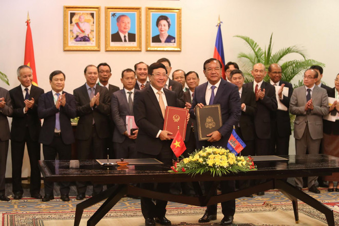 Phó Thủ tướng, Bộ trưởng Ngoại giao Phạm Bình Minh và Phó Thủ tướng, Bộ trưởng Bộ Ngoại giao và Hợp tác quốc tế Campuchia Prak Sokhonn ký kết văn kiện của Kỳ họp. (Ảnh: Trần Long/TTXVN) Việt Nam-Campuchia ký biên bản định hướng hợp tác 28 lĩnh vực ảnh 1