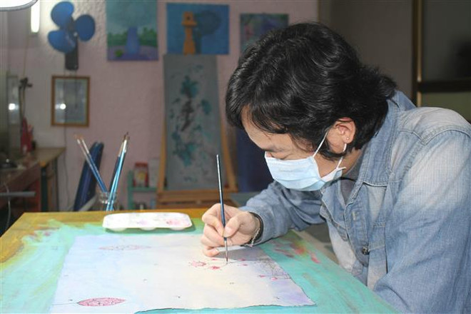 Họa sỹ Phan Tuấn Ngọc vẽ tranh với chủ đề 'Hãy ở nhà.' (Ảnh: Thùy Dung/TTXVN) Họa sỹ trẻ vẽ tranh tuyên truyền phòng, chống dịch COVID-19 ảnh 1