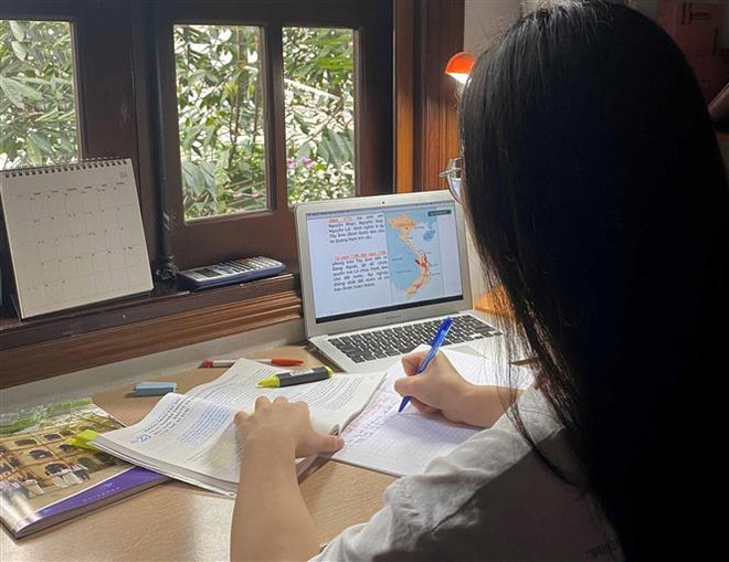 Học sinh Trường THPT Việt Đức (Hà Nội) học trực tuyến tại nhà. (Ảnh: TTXVN) Tuyển sinh đại học: Chuẩn bị nhiều phương án để đảm bảo chất lượng ảnh 1