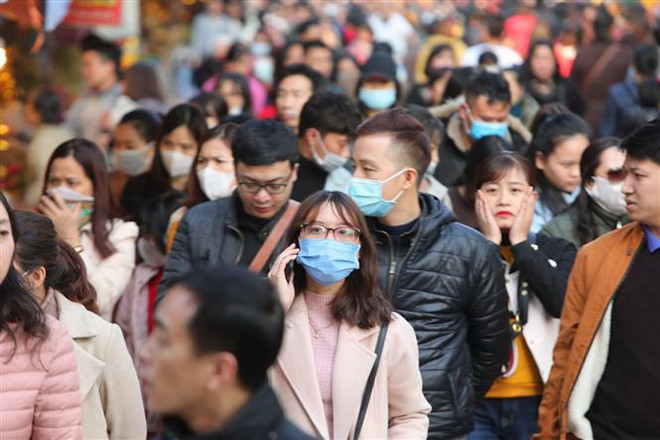 Đeo khẩu trang y tế ở những chỗ đông người để phòng ngừa virus corona. (Nguồn: TTXVN) Kích hoạt các phương án ngăn ngừa dịch viêm phổi do virus corona ảnh 1