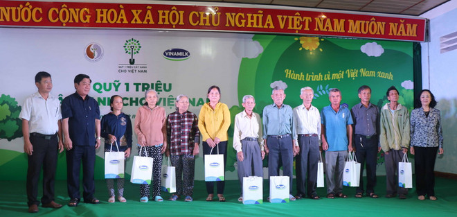Bà Trương Thị Mai - Ủy viên Bộ Chính trị, Bí thư Trung ương Đảng, Trưởng ban Dân vận Trung ương cùng các đại biểu trao tặng 10 phần quà của Ban Tổ chức cho các gia đình thuộc diện chính sách của tỉnh Bình Định. (Nguồn: Vinamilk) Vinamilk trồng 110.000 cây xanh góp phần phủ xanh tỉnh Bình Định ảnh 2