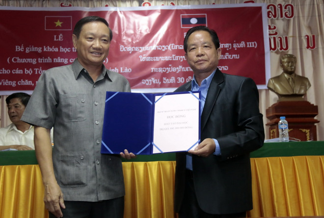 Đại sứ Nguyễn Bá Hùng trao cho đại diện Bộ An ninh Lào 1 suất học bổng trị giá 500 triệu đồng cho 1 cán bộ đạt kết quả xuất sắc của khóa học. (Ảnh: Phạm Kiên/Vietnam+) Bế giảng lớp học tiếng Việt cho cán bộ, chiến sỹ Bộ Công an Lào ảnh 1