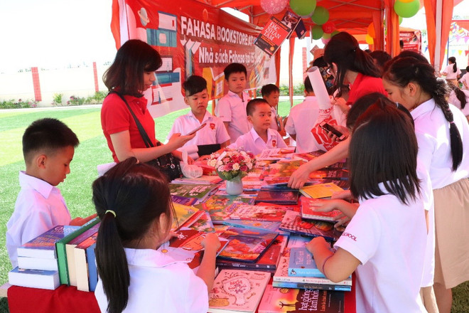 Các bạn học sinh tại Hệ thống trường Hội nhập Quốc tế iSchool hào hứng xem và chọn sách. (Ảnh: Vietnam+) Hấp dẫn Ngày hội khai giảng-Lan tỏa tri thức toàn cầu tại iSchool ảnh 1