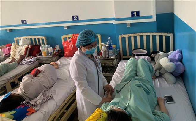 Kiểm tra tình trạng sức khỏe cho một thai phụ mắc sốt xuất huyết. (Ảnh: Đinh Hằng/TTXVN) Thủ tướng: Hạn chế thấp nhất trường hợp tử vong do sốt xuất huyết ảnh 1