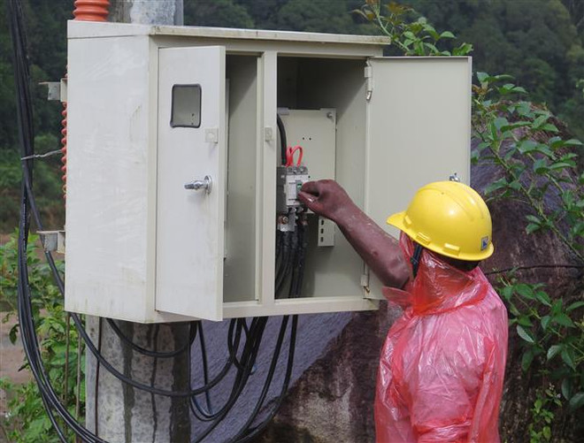 Công nhân điện lực đóng điện trạm biến áp điểm dân cư 57 hộ thuộc thôn Đăk Lanh, xã Măng Bút, huyện Kon Plông, tỉnh Kon Tum. (Ảnh: Dư Toán/TTXVN) Kon Tum: Kéo điện đến điểm dân cư cuối cùng của huyện Kon Plông ảnh 1